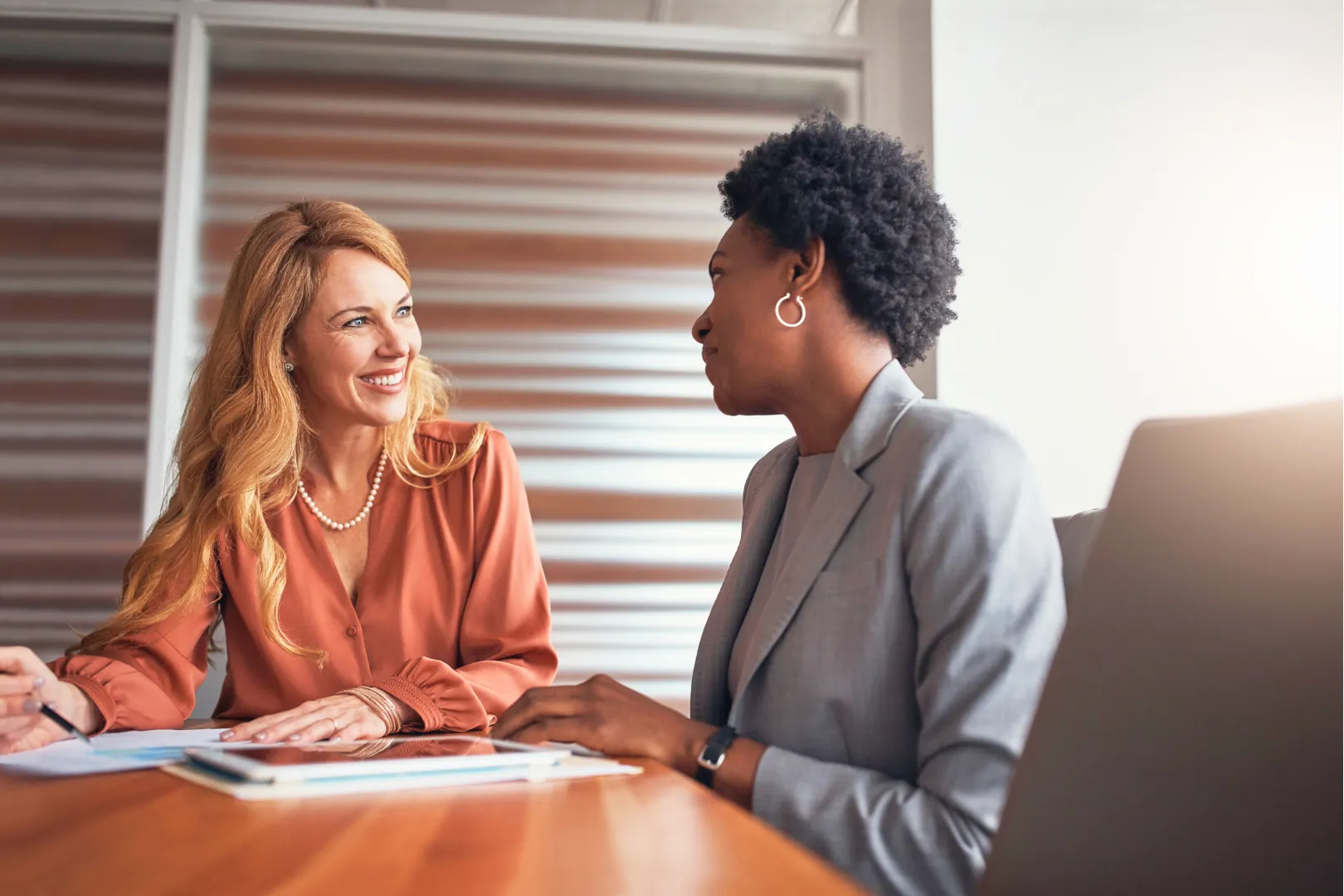 An Abuse Counseling & Therapy counselor smiles during a supportive meeting with a client.