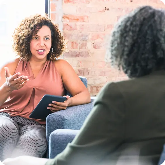An Abuse Counseling & Therapy counselor speaks warmly with a client during a supportive session.
