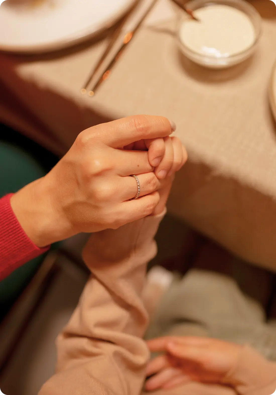 An adult gently holds a child's hand, representing the supportive care at Abuse Counseling & Therapy.