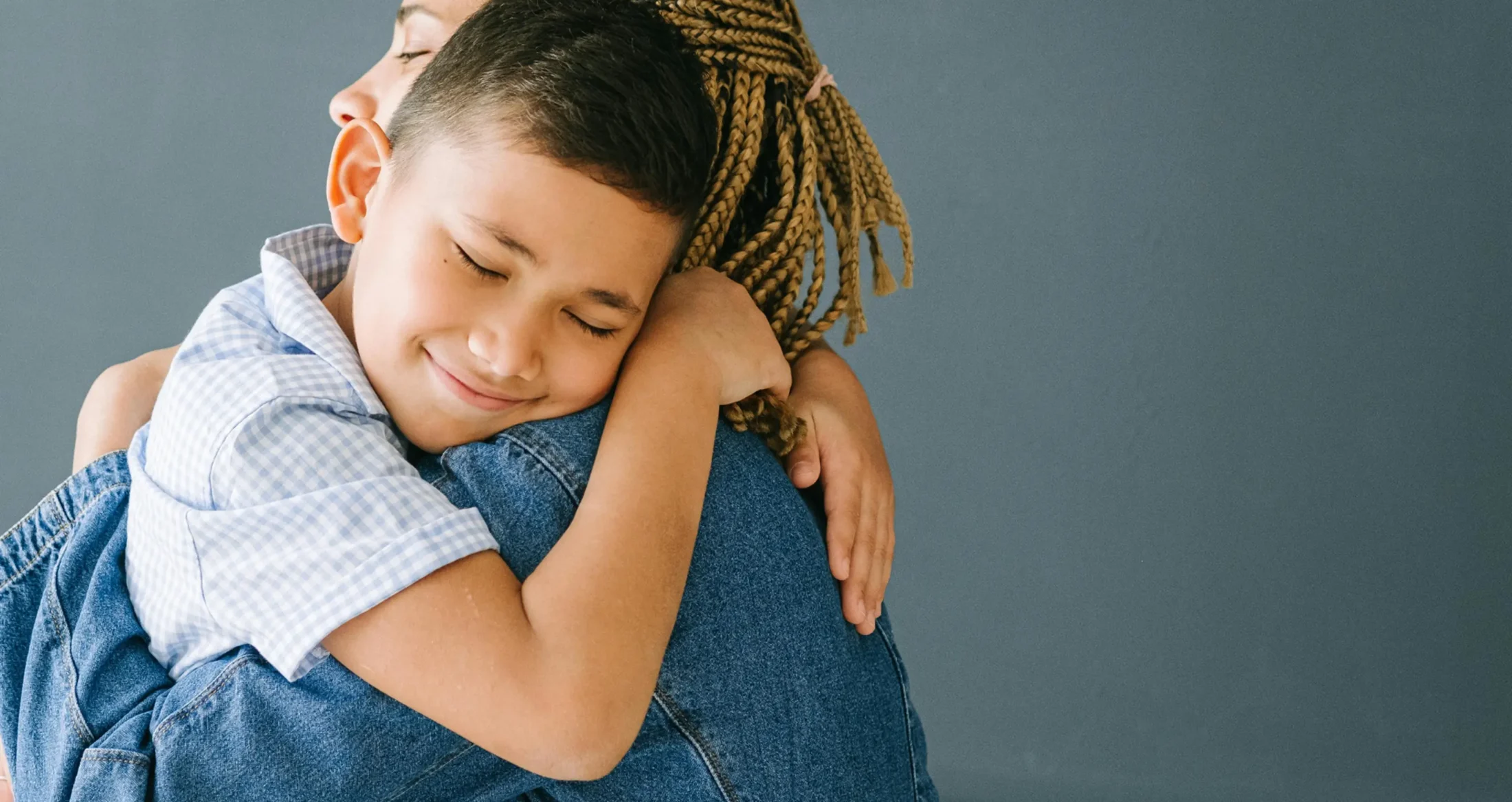 A young boy peacefully hugs his mother, reflecting the healing support of Abuse Counseling & Therapy.