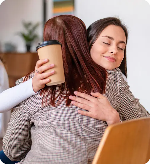 A counselor at Abuse Counseling & Therapy embraces a client in a warm, supportive hug.