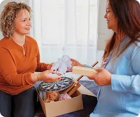 An Abuse Counseling & Therapy counselor hands therapeutic activities and supplies to a client.