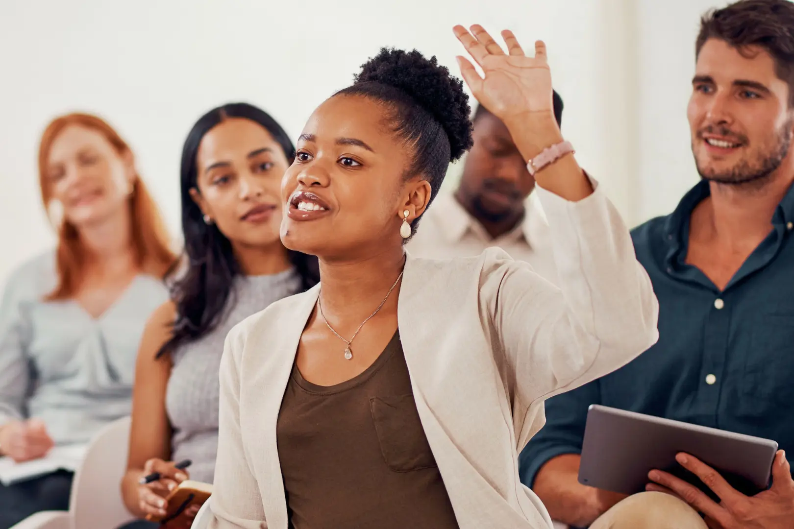 A woman raises her hand to speak during an Abuse Counseling & Therapy support group session.