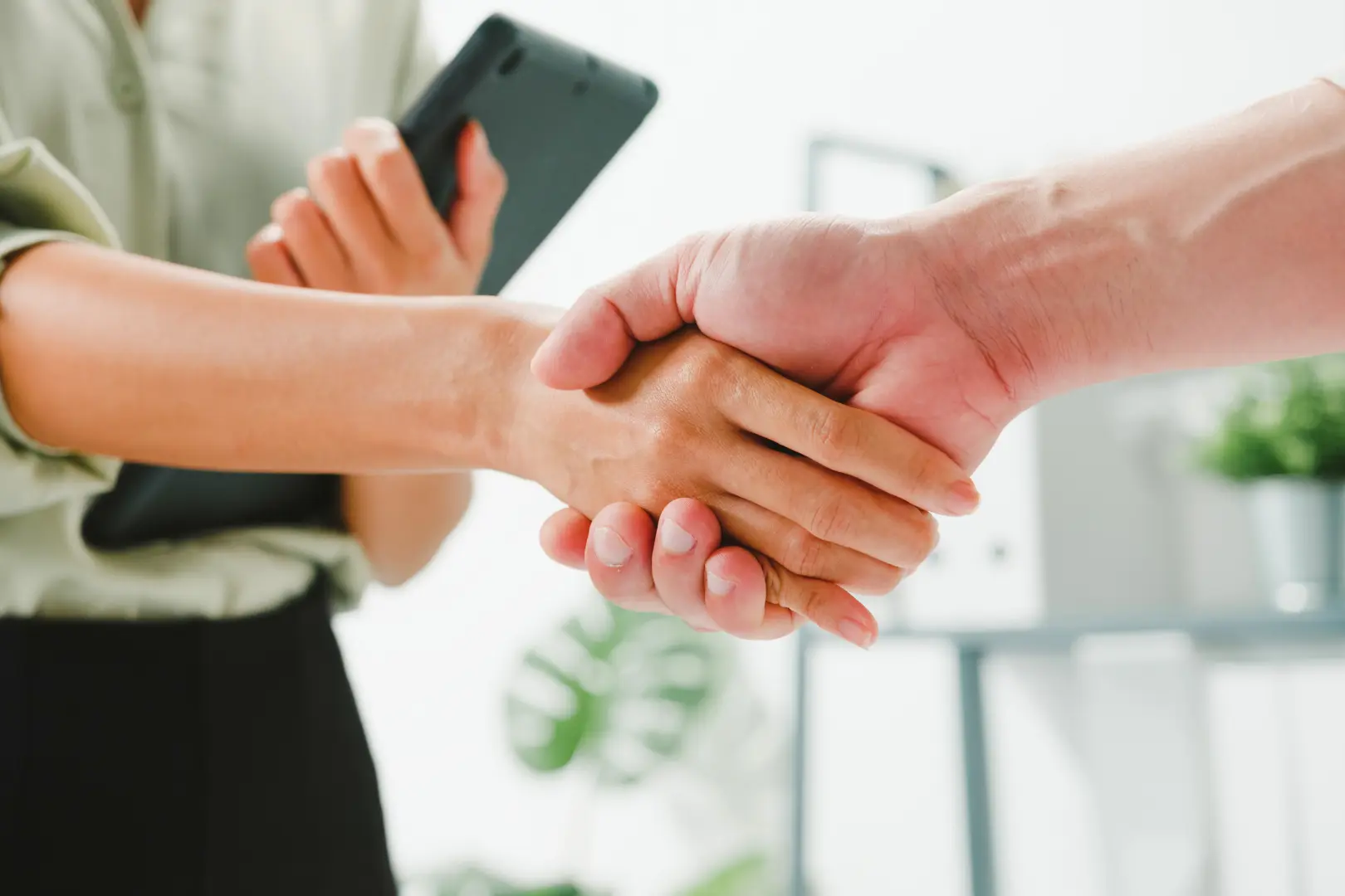 An Abuse Counseling & Therapy counselor shakes hands with a client in a welcoming office.