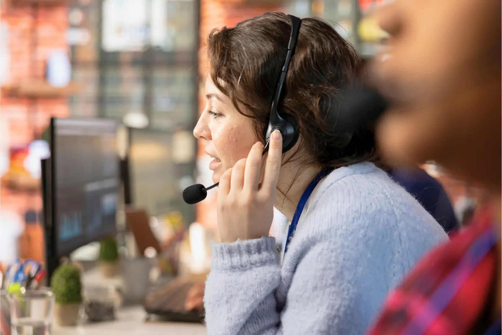 An Abuse Counseling & Therapy helpline operator wearing a headset speaks with a caller.