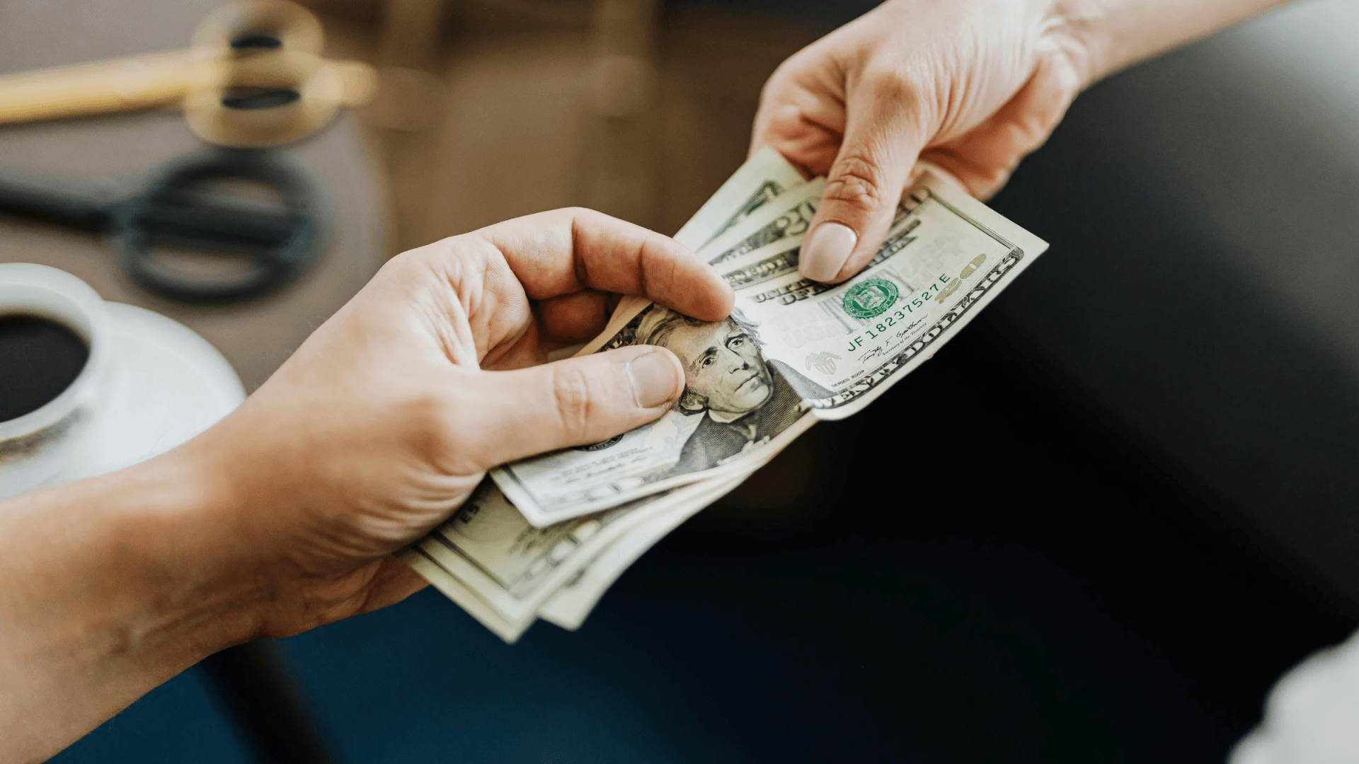 Hands exchanging cash donations to fund free survivor services at Abuse Counseling & Therapy.