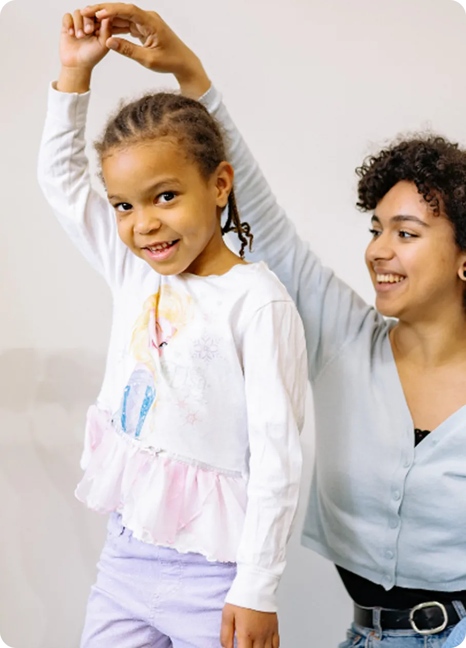 A smiling child dances with a supportive counselor at Abuse Counseling & Therapy.