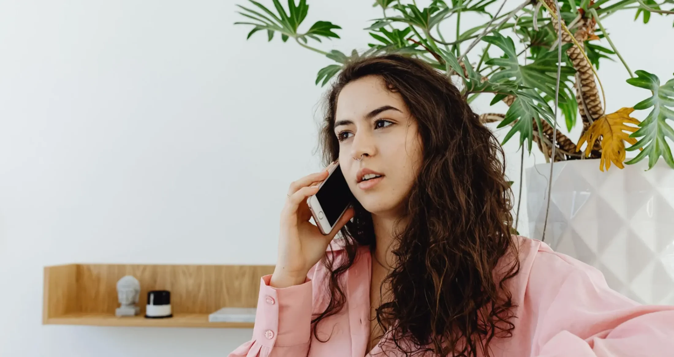 A woman speaks on her phone, contacting Abuse Counseling & Therapy for free, confidential support.