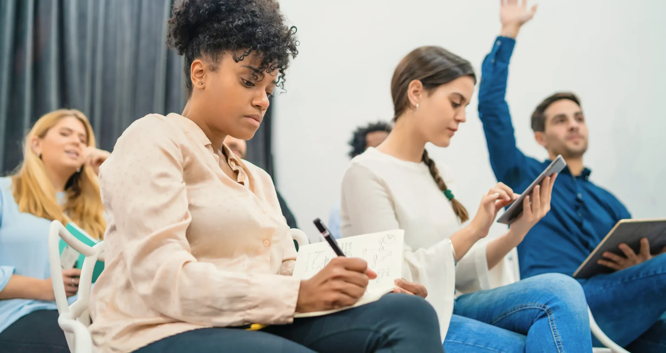 Diverse participants take notes during an Abuse Counseling & Therapy educational seminar.
