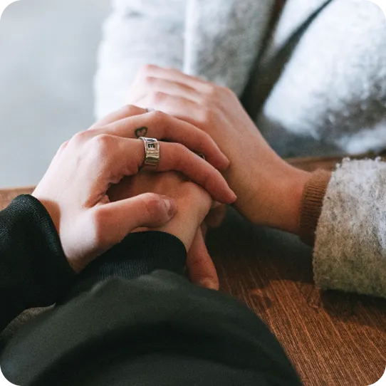 Hands clasped in comfort and support during an Abuse Counseling & Therapy session.