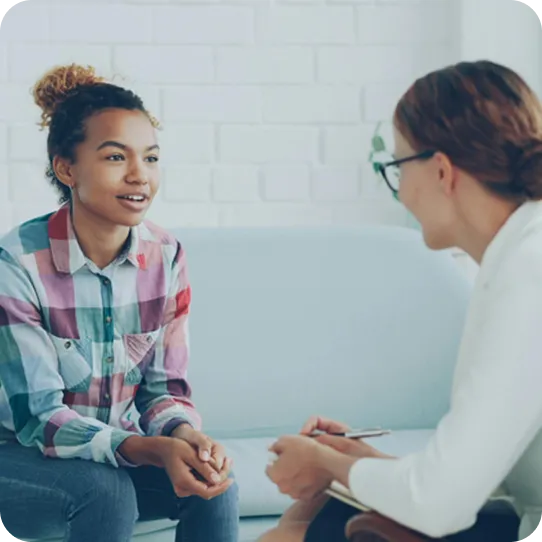 A young woman speaks with a supportive counselor during an Abuse Counseling & Therapy session.