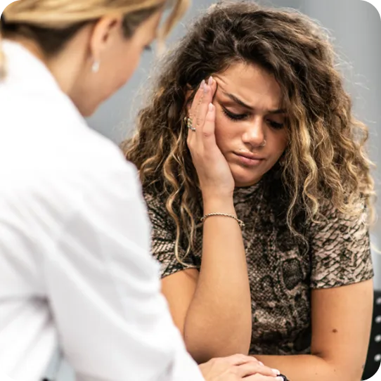 A counselor at Abuse Counseling & Therapy comforts a distressed young woman during a support session.