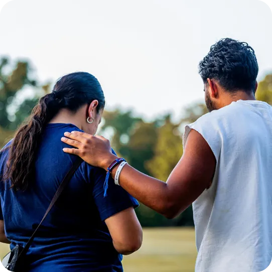 A man places a comforting hand on a woman's shoulder, showing the supportive care of Abuse Counseling & Therapy.