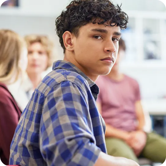 A thoughtful teen boy participates in an Abuse Counseling & Therapy support group.