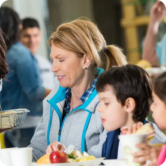 A mother and child enjoy a meal together at an Abuse Counseling & Therapy community shelter.