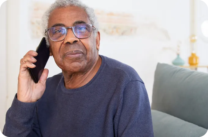 An older man with glasses speaks on a phone call with Abuse Counseling & Therapy.
