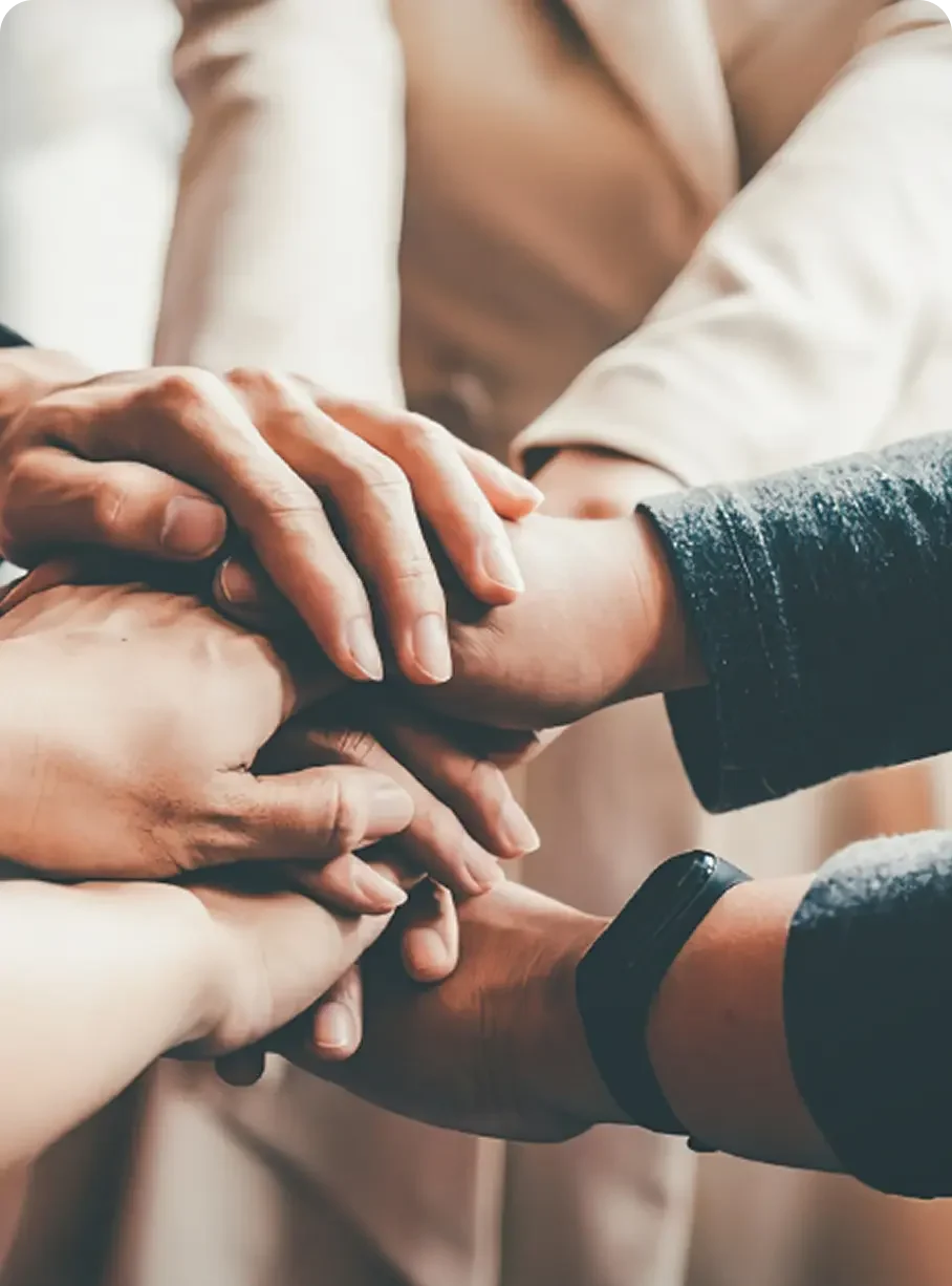 Diverse hands stack together, symbolizing the supportive community at Abuse Counseling & Therapy.