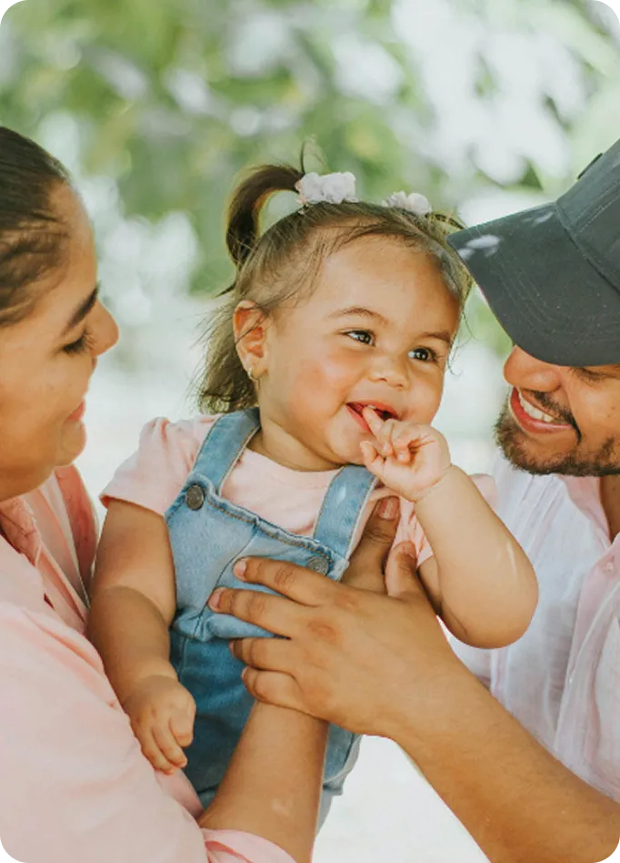 A happy family supported by Abuse Counseling & Therapy holds their smiling toddler.