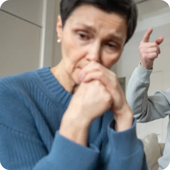 A distressed woman looks fearful as someone points aggressively, supported by Abuse Counseling & Therapy.