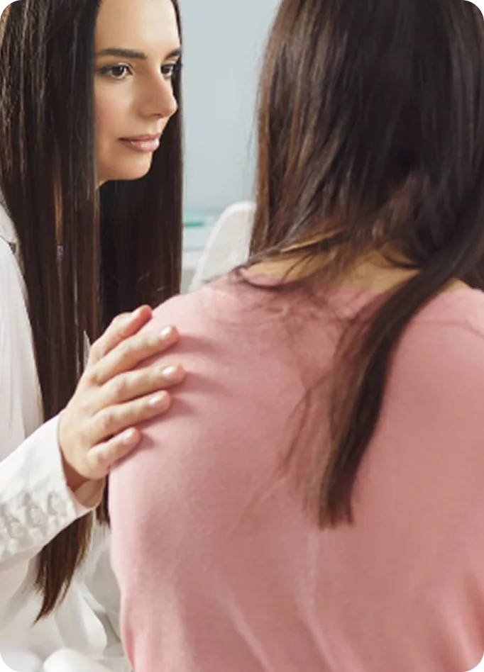 An Abuse Counseling & Therapy counselor places a supportive hand on a client's shoulder.