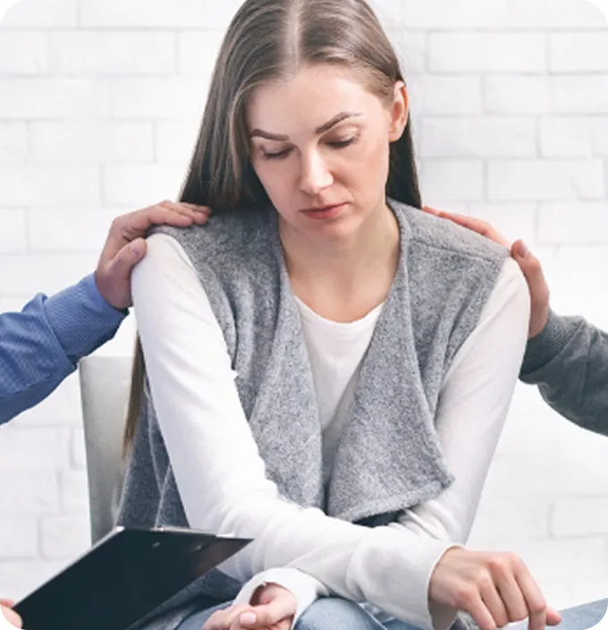 Hands offer comforting support to a sad woman during an Abuse Counseling & Therapy session.