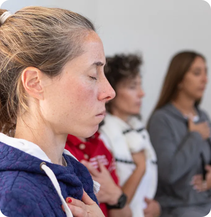 Women practice mindfulness with hands on their chests in an Abuse Counseling & Therapy support group.