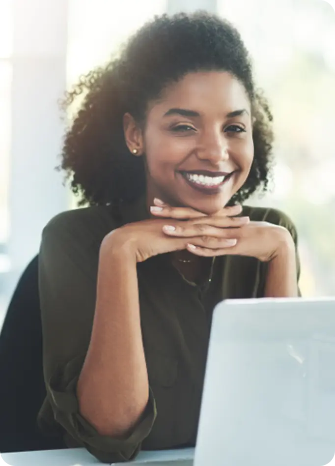 A welcoming counselor at Abuse Counseling & Therapy smiles warmly while working at her laptop.
