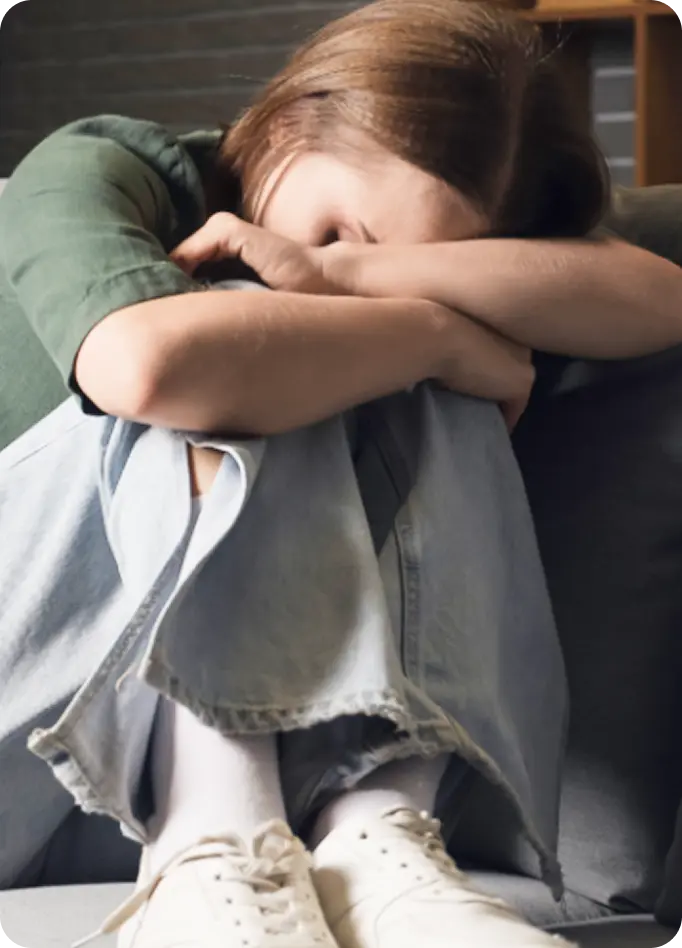 110 characters. Perfect. * Let's make it even more natural: "A distressed person curls up on a sofa, representing those supported by Abuse Counseling & Therapy.
