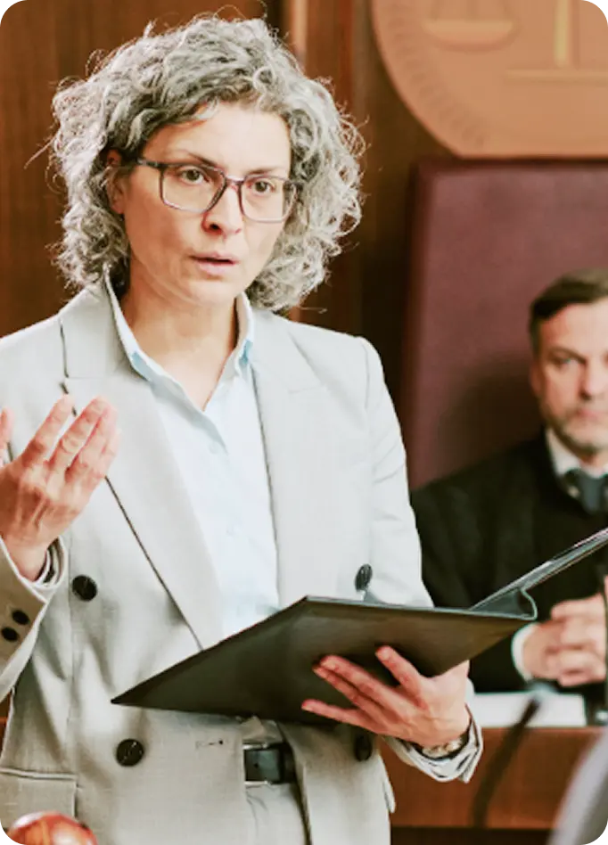 An Abuse Counseling & Therapy advocate speaks in court while holding a legal folder.