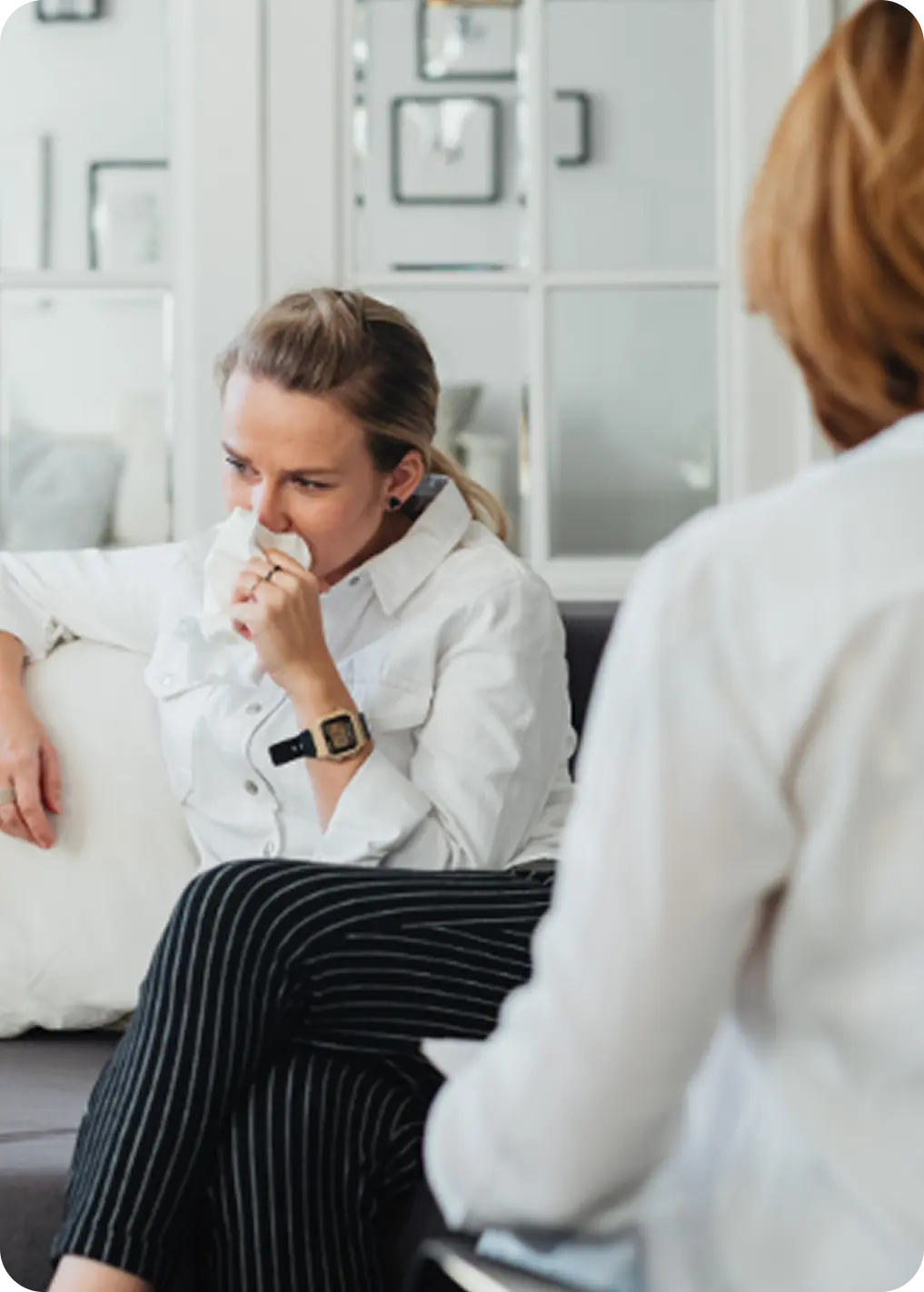 A woman wipes away tears during a supportive session at Abuse Counseling & Therapy.