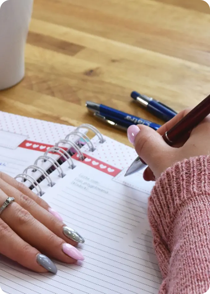 A client journals in a notebook during an Abuse Counseling & Therapy session.