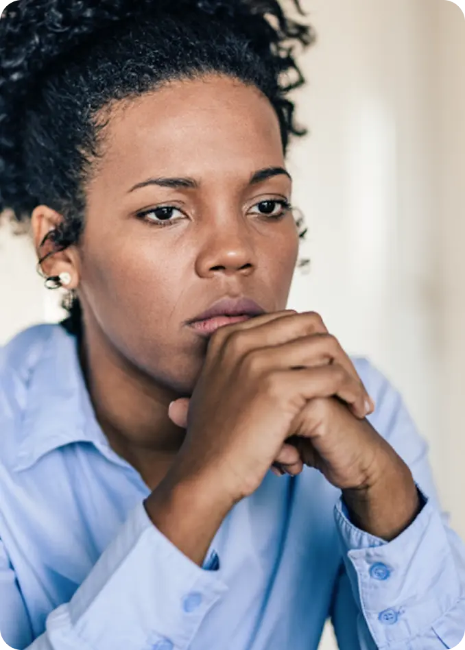 A pensive woman with clasped hands, representing survivors supported by Abuse Counseling & Therapy.