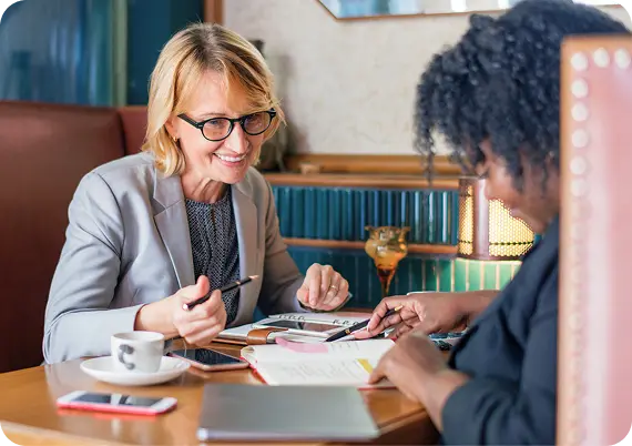 An Abuse Counseling & Therapy counselor smiles warmly while reviewing notes with a client.