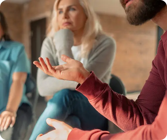 A man gestures while speaking during a group support session at Abuse Counseling & Therapy.