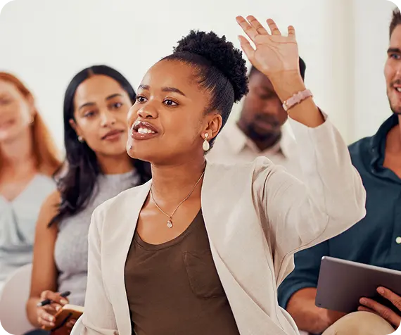 A woman raises her hand to speak during an Abuse Counseling & Therapy group support session.