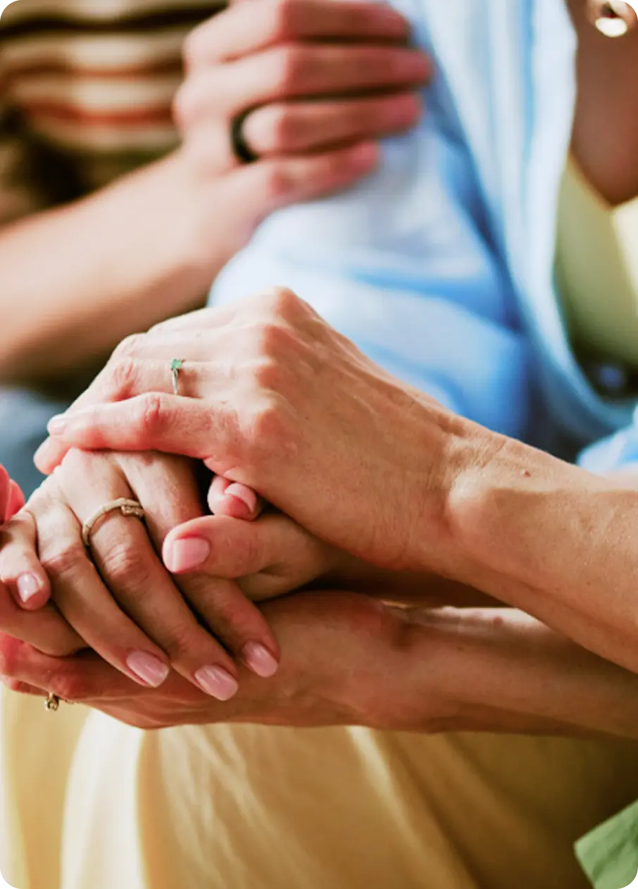 Hands clasped in comfort and support, representing care at Abuse Counseling & Therapy.