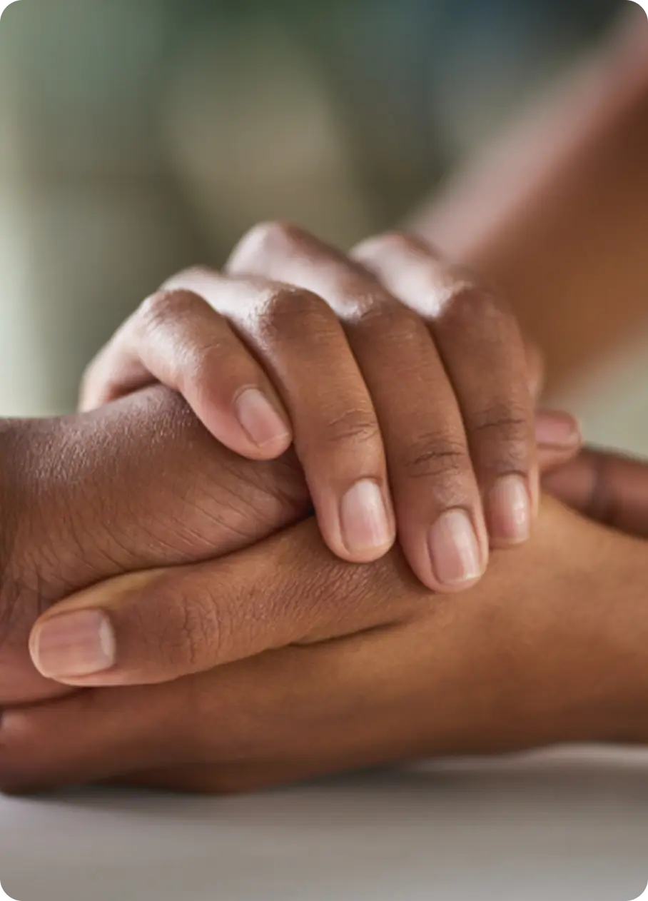 Two hands clasped in support, symbolizing the healing care at Abuse Counseling & Therapy.