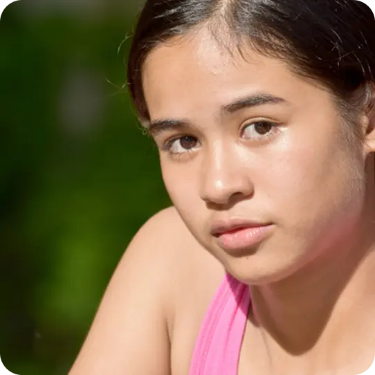 A young woman with a serious expression, representing survivors supported by Abuse Counseling & Therapy.